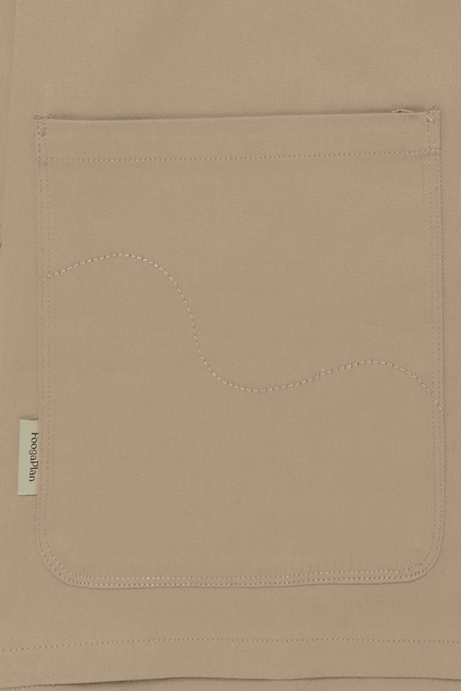 Detalle bolsillos carpenter y manga raglan sobrecamisa beige