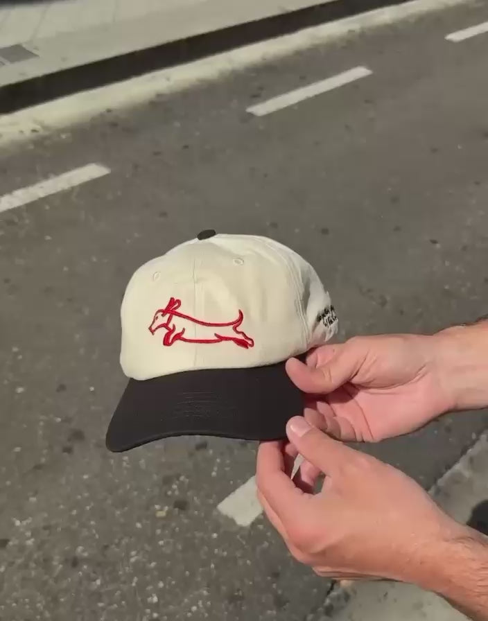 Gorra Foogaplan color beige y negra con diseño de perro salchicha rojo bordado