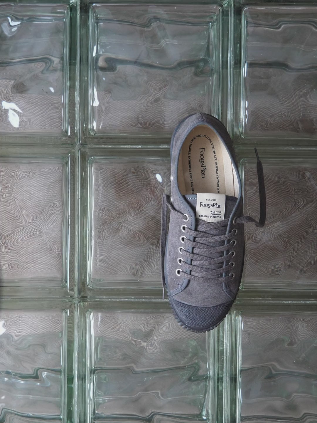 Zapatillas CHUCK Thunder Suede de FoogaPlan en serraje gris, mostradas de perfil y desde arriba sobre una mesa de vidrio.